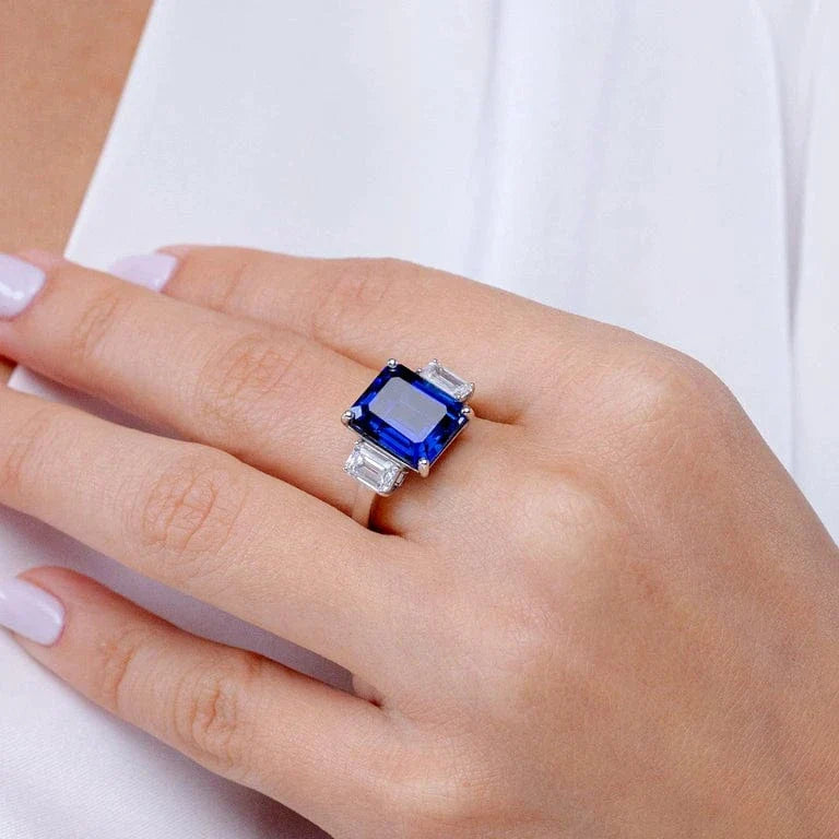 Emerald-Cut 5.5CT Royal Blue Lab-Grown Sapphire Engagement Ring – Three Stone Classic Design with Moissanite Side Stones, 14K Yellow Gold Plated on Tarnish-Resistant Silver(Includes GRC Certification from Gemstone Research Center)
